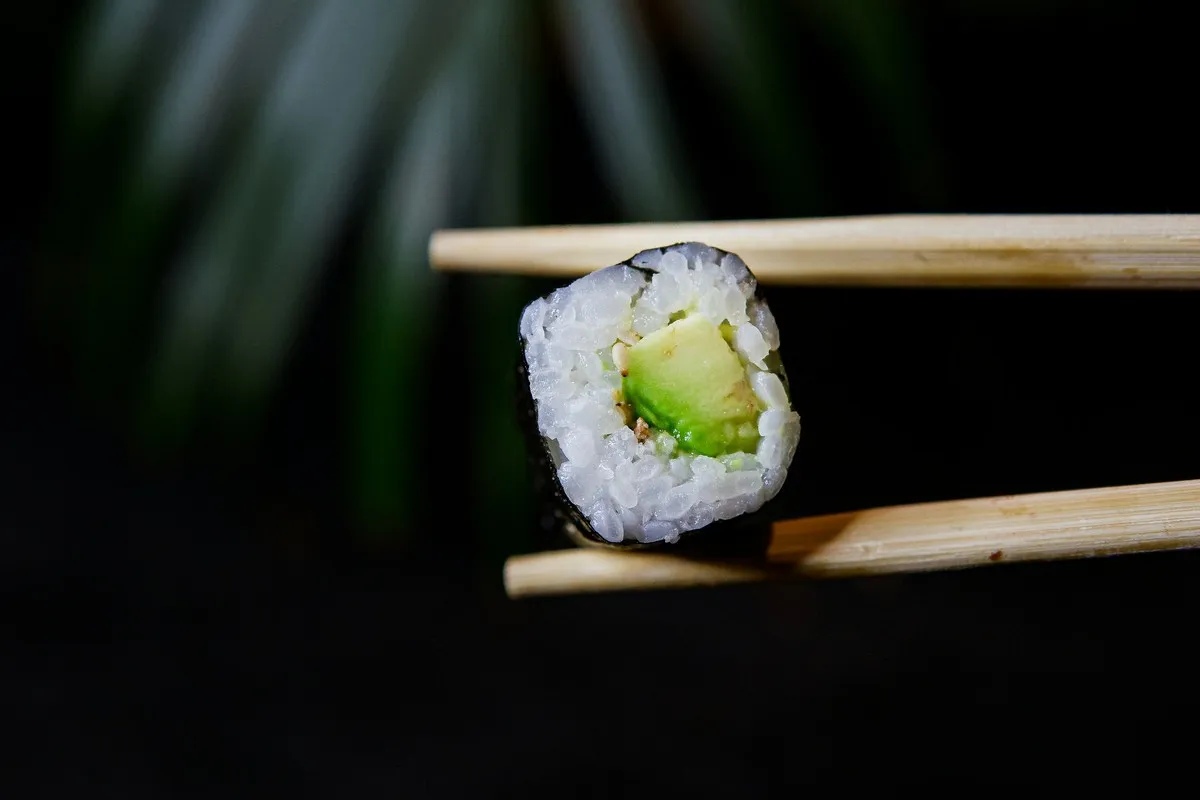 Un maki tenu aux baguettes
